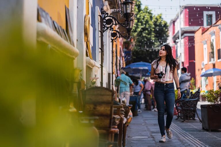 カメラを手にメキシコのカラフルな街並みを散策する女性旅行者