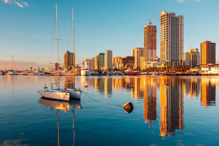 マニラ湾に浮かぶヨットと高層ビル群が水面に映るフィリピン・マニラの都市景観