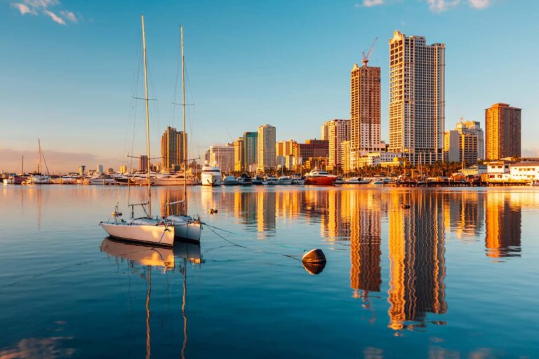 マニラ湾に浮かぶヨットと高層ビル群が水面に映るフィリピン・マニラの都市景観