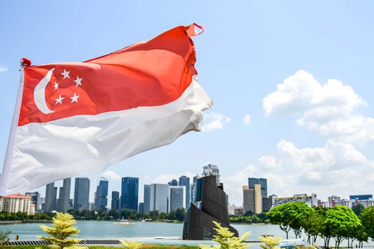 シンガポールの都市景観を背景にはためくシンガポール国旗のイメージ