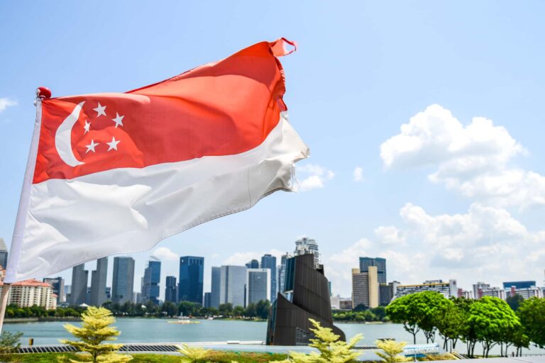 シンガポールの都市景観を背景にはためくシンガポール国旗のイメージ