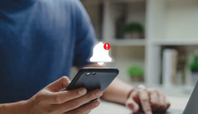 スマートフォンに表示された不審な通知ベルと警告マークのイメージ