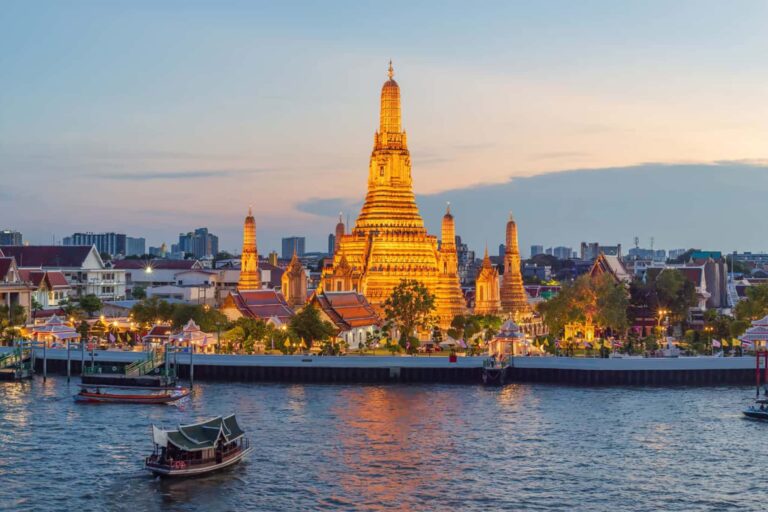 チャオプラヤー川越しに夕暮れのワット・アルンが輝くバンコクの夜景イメージ