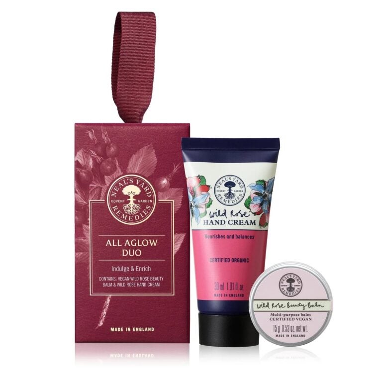 イギリス発のオーガニックコスメ「ニールズヤード レメディーズ」のギフトセット。ワイルドローズのハンドクリームとビューティーバームが、ブランドを象徴するボルドーのボックスに収められた様子。