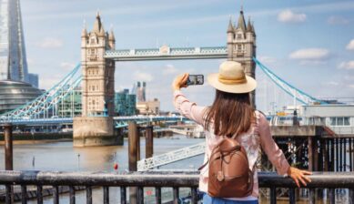 イギリス・ロンドンのタワーブリッジで、ヨーロッパの治安に注意を払いながらスマートフォンで撮影を楽しむ女性旅行者の様子。