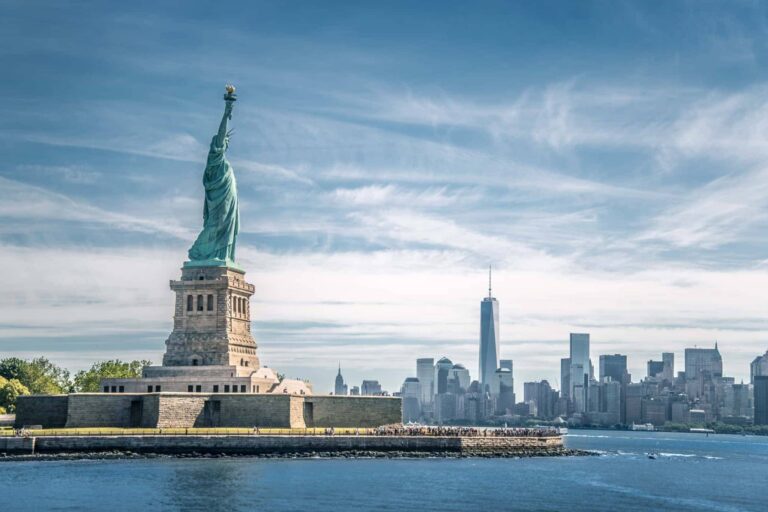 マンハッタンの高層ビル群を背景にそびえるニューヨークの自由の女神像