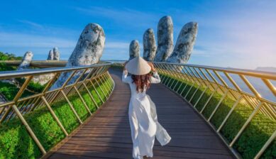 ダナンのゴールデンブリッジでアオザイを着て歩く女性の後ろ姿