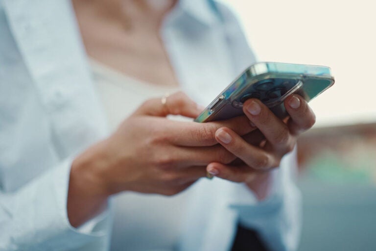 海外WiFiに接続しながらスマートフォンを操作する女性のイメージ