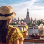 バンコクのリバーサイドカフェからワット・アルンを眺める旅行者