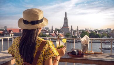 バンコクのリバーサイドカフェからワット・アルンを眺める旅行者