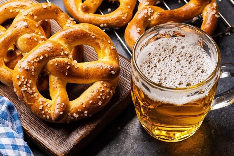 ドイツビールのジョッキと岩塩がかかった焼きたてプレッツェルの組み合わせ