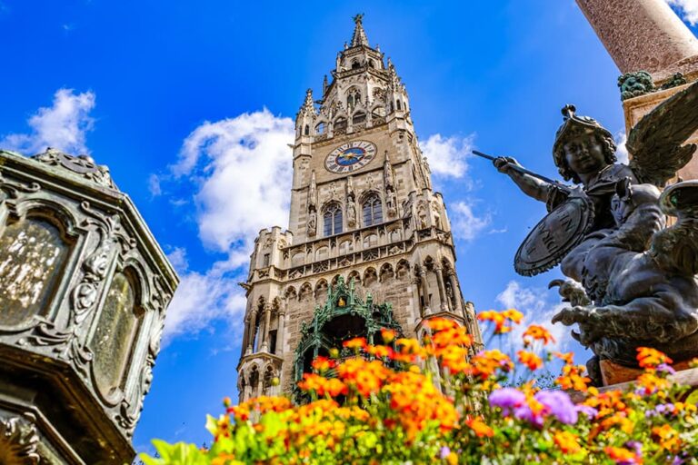 ミュンヘン新市庁舎の時計塔と天使の彫像を花越しに見上げた風景