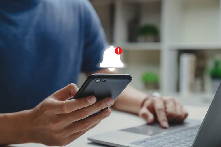 スマートフォンにセキュリティ警告が表示され、パソコンと併用して対処している様子