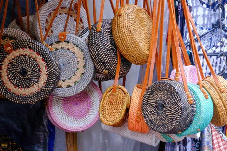 バリ島のお土産店に並ぶさまざまな柄のアタ製丸型ショルダーバッグ