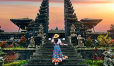 夕焼けのバリ島寺院の割れ門を訪れる旅行者