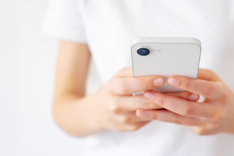 両手でiPhoneを持ち、画面を確認している様子