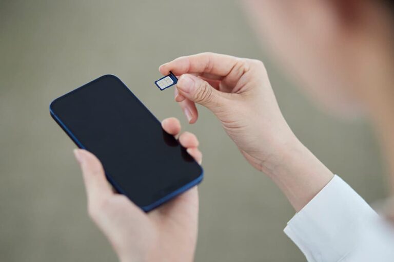 女性がiPhoneにnanoSIMカードを差し込もうとしている様子