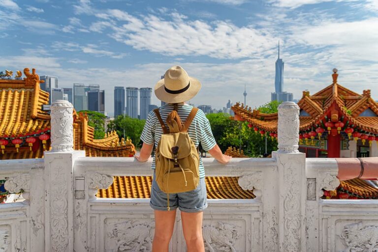 クアラルンプールの中華寺院から都市のスカイラインを眺める女性観光客の後ろ姿