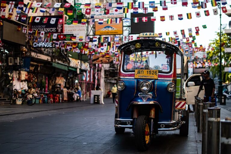 万国旗が飾られたバンコクの繁華街を走るトゥクトゥク