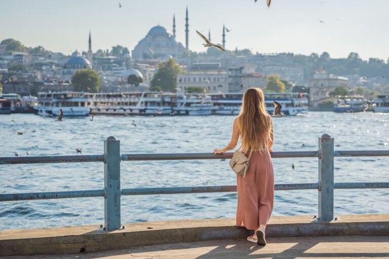 イスタンブールの海沿いからモスクの街並みを眺める女性旅行者