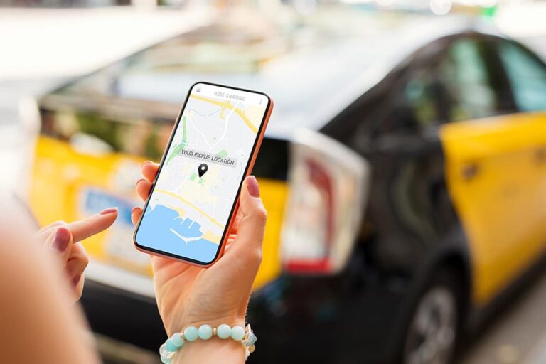 タクシーの前でライドシェアアプリの地図を操作するスマートフォン画面