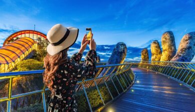 ダナンのゴールデンブリッジでスマホ撮影を楽しむ女性観光客