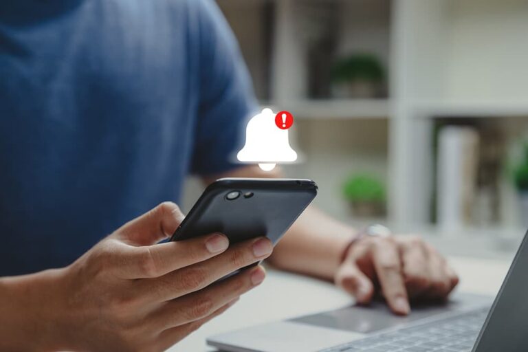 スマートフォンに届いた警告通知を確認する旅行者の手元