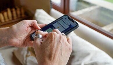 窓辺でスマートフォンのメッセージアプリを操作する手元のクローズアップ。電話番号なしでWhatsAppを使う方法を示す一枚