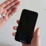 eSIMアダプターと非対応スマホを手に持つ様子
