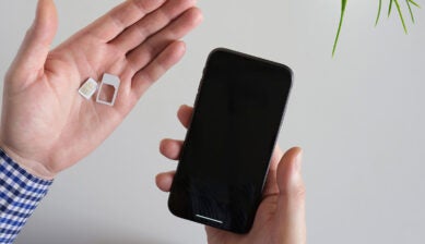 eSIMアダプターと非対応スマホを手に持つ様子