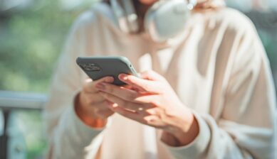 海外でSMSを受信するためにスマートフォンを操作する女性