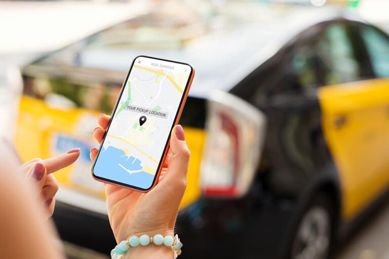 ニューヨークのタクシー前でスマホの地図アプリを操作する女性