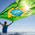 コルコバードのキリスト像を望むリオデジャネイロの絶景を背景にブラジル国旗を掲げる人物