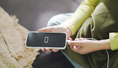 バッテリー残量が少なくなったスマートフォンに充電ケーブルを差し込む様子。中国旅行中の充電準備の重要性を示す一枚