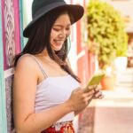 街中でスマホを見る女性の画像。外出先でTikTokを利用する際の通信量をイメージしている一枚