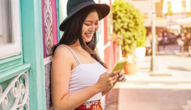 街中でスマホを見る女性の画像。外出先でTikTokを利用する際の通信量をイメージしている一枚