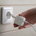 バリ島のCタイプコンセントに、Cタイプ変換プラグを付けた充電器を差し込もうとする手元