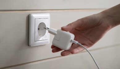 バリ島のCタイプコンセントに、Cタイプ変換プラグを付けた充電器を差し込もうとする手元