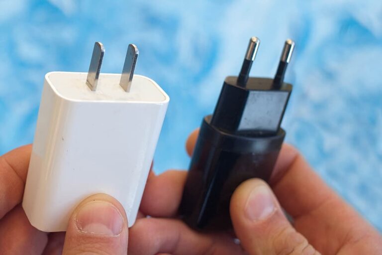 平たいピン2本の日本のAタイプと、丸いピン2本のヨーロッパのCタイプの充電器プラグを並べて比較する手元