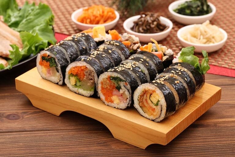木製トレイに盛られた具だくさんのキンパと小皿のおかず、辛くなく子どもも食べやすい韓国料理