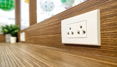木目の壁に設置されたセブ島のマルチタイプコンセント。A・C両対応で日本のプラグもそのまま挿せる