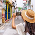 シンガポールのカラフルな街並みでスマホ撮影を楽しむ女性旅行者の後ろ姿