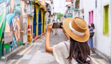 シンガポールのカラフルな街並みでスマホ撮影を楽しむ女性旅行者の後ろ姿