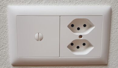 スイスの壁に設置されたJタイプのコンセント。丸いピン穴が3つある差込口が縦に2口並んでいる