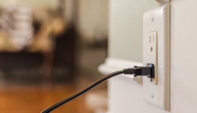壁のコンセントにプラグを差し込んで充電する台湾旅行の電源イメージ