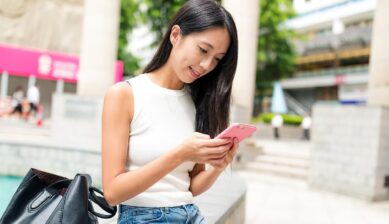 海外でスマートフォンの通信設定を確認する旅行者のイメージ