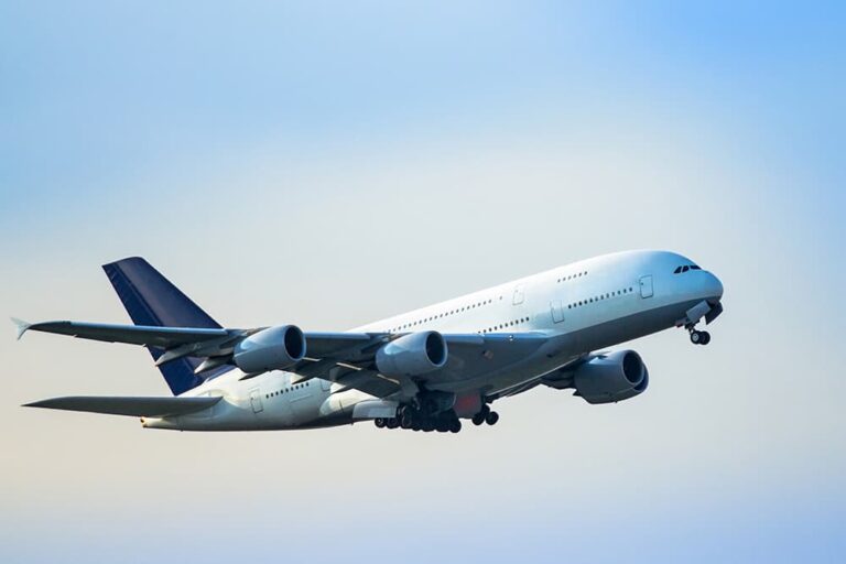 台湾旅行の航空券費用をイメージさせる、青空を飛ぶ旅客機の写真