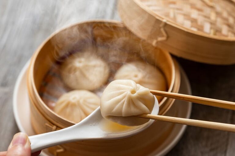台湾旅行の食費をイメージさせる、蒸籠に入った小籠包を箸で持ち上げる写真