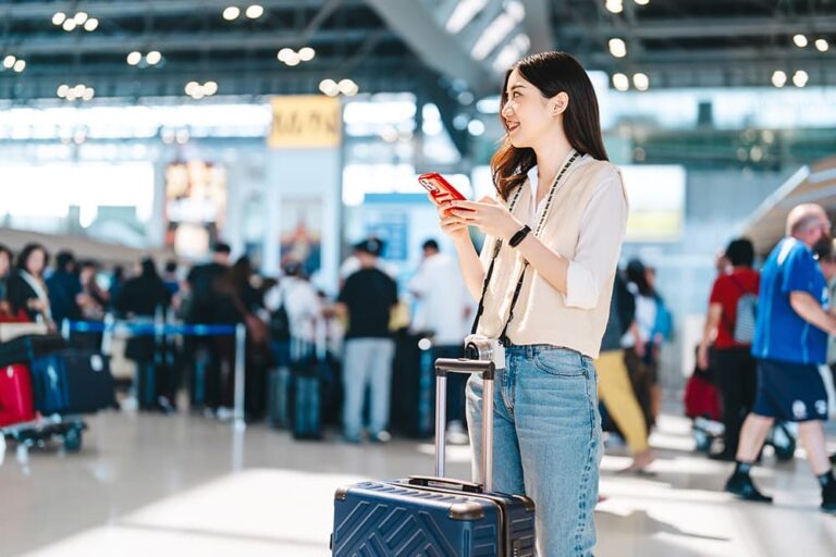台湾旅行の通信費をイメージさせる、空港でスマホを確認する旅行者の写真