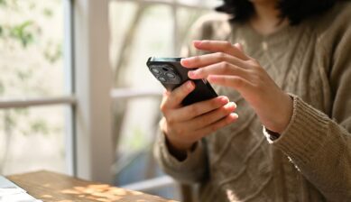 スマホで海外旅行用eSIMを確認する人｜Holaflyとトリファの比較